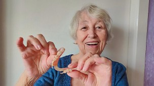 a lady taking out her partial denture