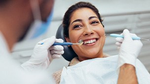 woman having her teeth cleaned at the dentist’s office
