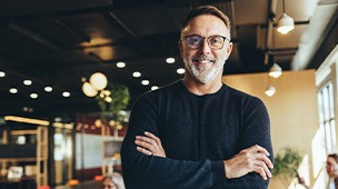a man with glasses smiling