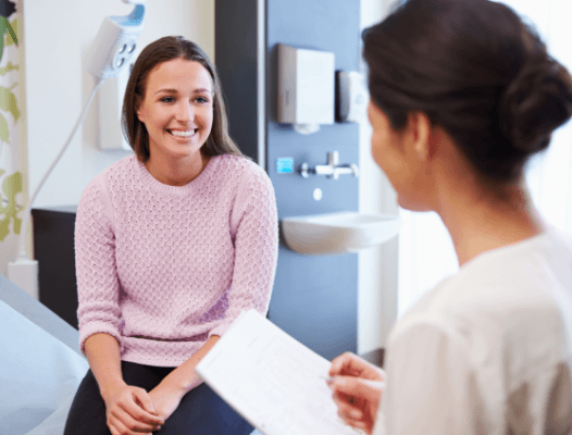 Woman in dental exam room smiling at dentist