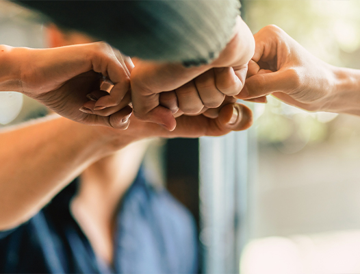 Group of people placing their hands together in a circle