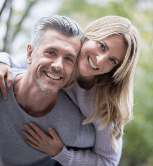 Man and woman smiling after visiting the dentist