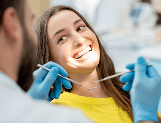 Woman in dental chair smiling at the dentist