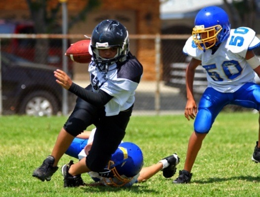 Kids wearing sportsguards playing football