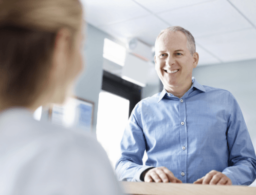 Smiling man checking in at dental office