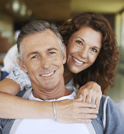 Man and woman smiling after cosmetic dental bonding