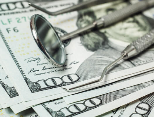 money laying underneath dental instruments