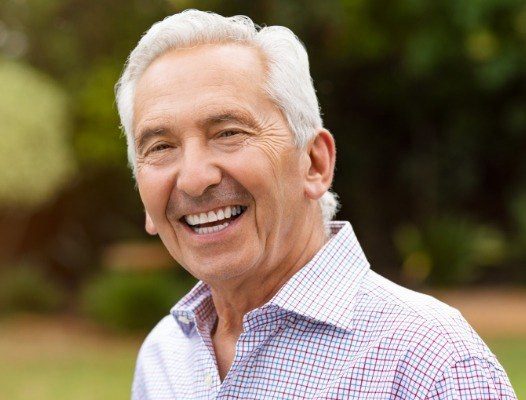 Older man with healthy smile after dental crown and bridge restoration