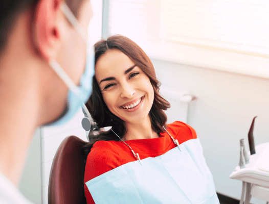 Woman in dental chair smiling at dentist