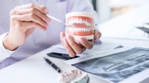 Dentist pointing to smile model before dental implant surgery