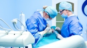 Dentist performing dental implant surgery