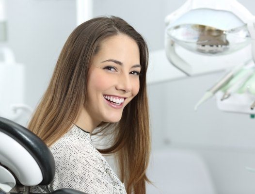 Woman smiling in dental chair for preventive dentistry