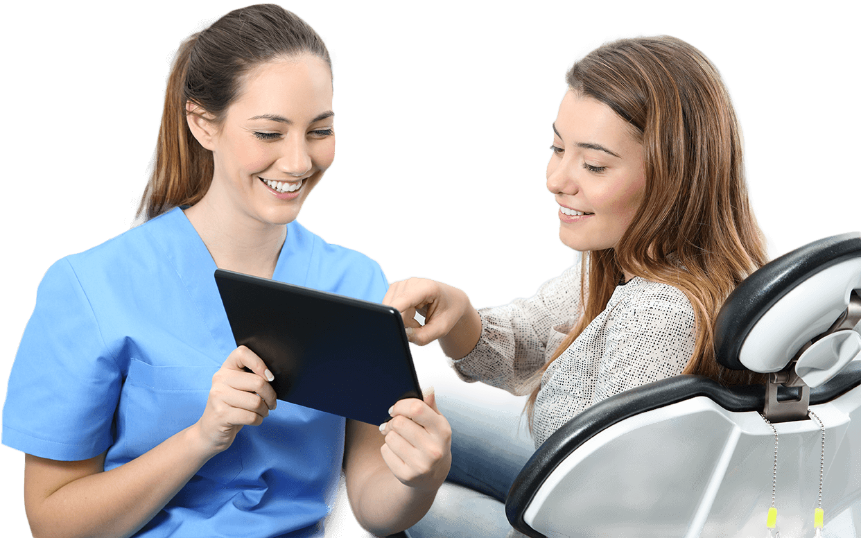 Woman and dental team member looking at tablet computer