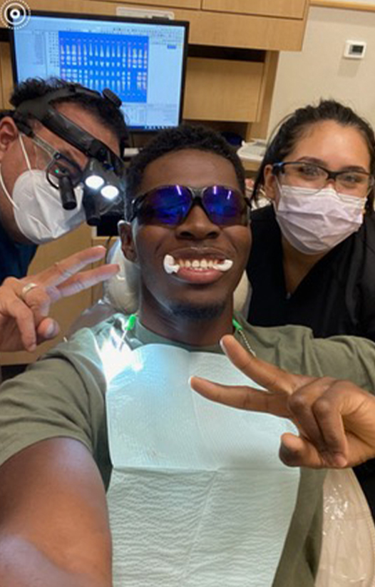 Dentist and dental team member smiling with dental patient