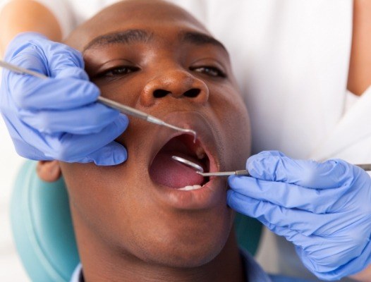 Dentist performing oral cancer screening