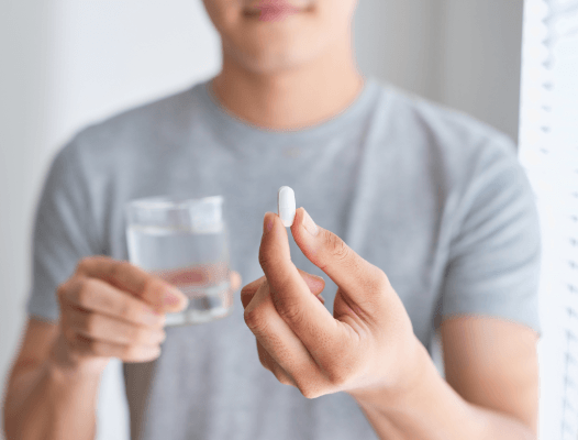 Patient holding oral conscious dental sedation pill