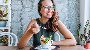 a woman eating a yogurt parfait