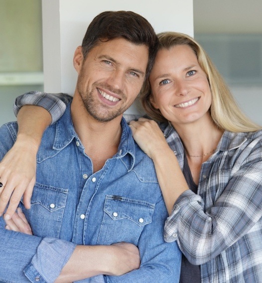 Man and woman sharing healthy smiles after preventive dentistry