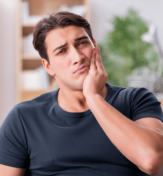 Man in need of root canal therapy holding cheek in pain