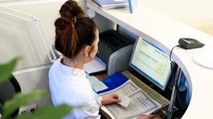 Dental receptionist looking at dental insurance in DuPont