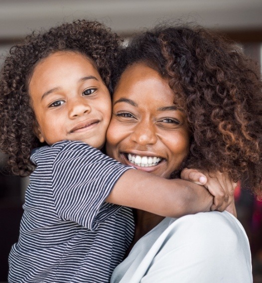 Mother and child with healthy smiles after dental sealants