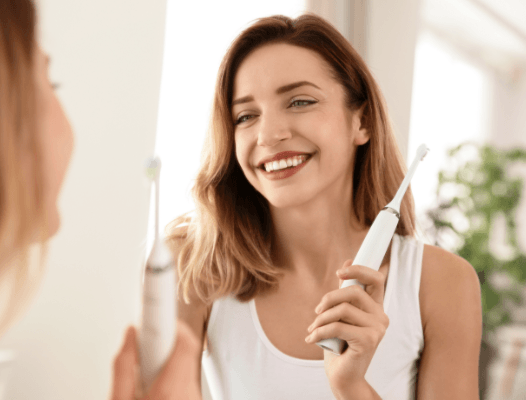 Woman looking at bright smile after brushing teeth