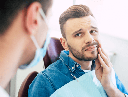 Man holding jaw in pain before T M J therapy