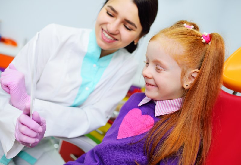 a little girl sitting in the dentist’s chair