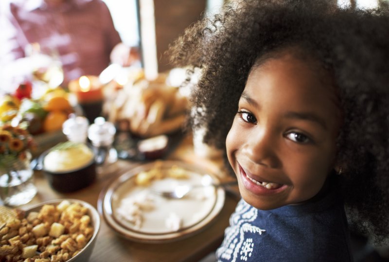 a young girl smiling at the Thanksgiving table