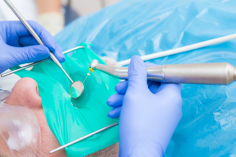 a dentist performing a root canal on a patient in need