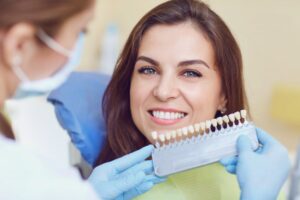 a cosmetic dentist matching the shade of a patient's teeth