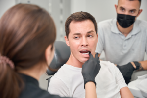 a dentist inspecting a patient's tooth